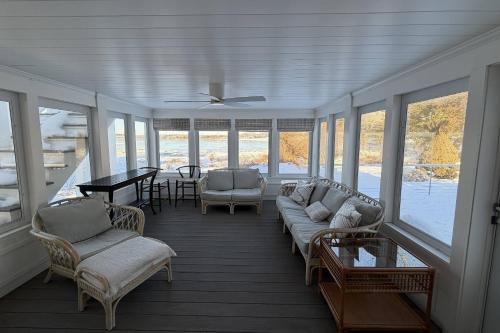 a screened in porch with a couch and chairs and a table at Perfectly Scitu8ed - Scituate in Scituate