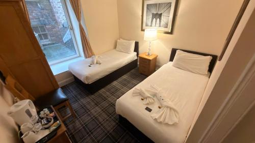 a small room with two beds and a window at The Waverley Guest House in Inverness