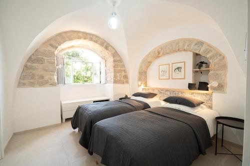 three beds in a room with a stone wall at חקל תפוחין 1 - Hakal-Tapuchin 1 in Safed