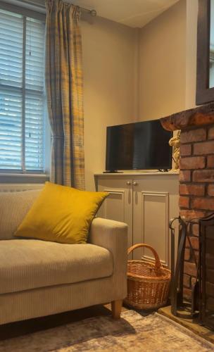 a living room with a couch and a television at No 1 Chapel Row in Bakewell