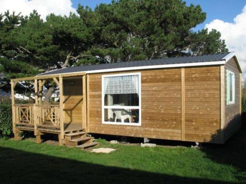 a wooden cabin with a porch and a window at Camping La Pointe du Talud in Ploemeur