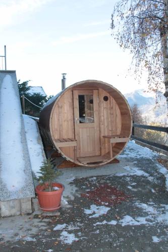 a round wooden hobbit house in the snow at Chambres D'Hotes Les Fleurs in Pila