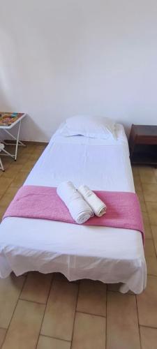 a white bed with two pillows on top of it at Casa Mineira in Capitólio