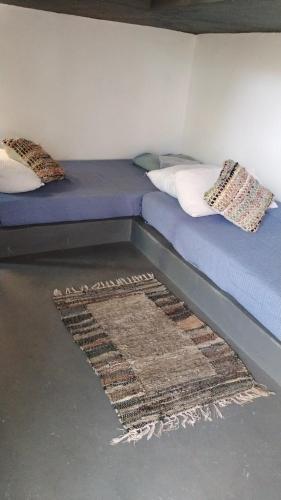 a bed in a room with a rug on the floor at Mini Relajo-Tiny House in Pirque