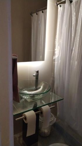 a bathroom with a glass sink and a mirror at Mini Relajo-Tiny House in Pirque