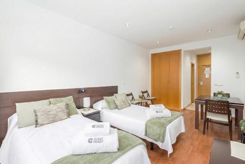 a hotel room with two beds and a desk at GuestReady - Domocenter studio with garage in Bormujos