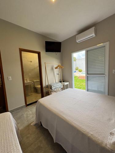 a bedroom with a large bed and a window at Suítes Brotas in Brotas