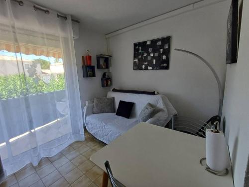 a living room with a couch and a window at Charmant studio à Balaruc-les-Bains avec parking inclus - FR-1-571-68 in Balaruc-les-Bains