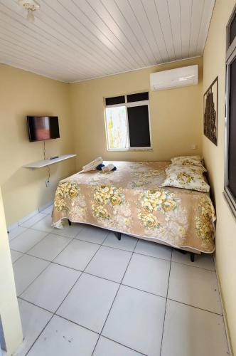 a bedroom with a bed and a tiled floor at Suíte Conforto - Leve, Prático e Acolhedor in Itacaré