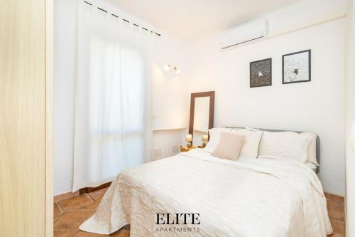 a white bedroom with a bed and a window at Elite Collection Domo Mea Private Pool in Olbia