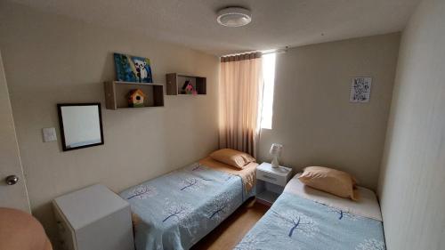 a bedroom with two twin beds and a window at Apartamento Varela in Lima