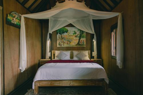 a bedroom with a bed with a canopy at Bedugulhome in Bedugul