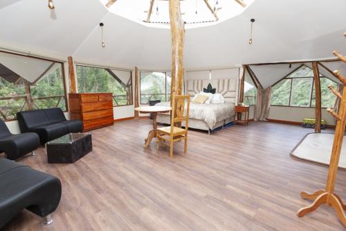 a bedroom in a tent with a bed and a couch at Caisae Eco-Lodge in San Antonio