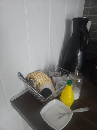 a bathroom counter with a sink and a container and a vase at Takelvdal in Björklid