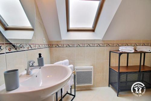 a bathroom with a sink and two skylights at La maison de chris in Theix