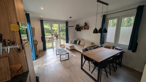 a living room with a table and a couch at Rustige natuur lodge bij Deventer met privé terras in Gorssel