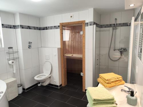 a bathroom with a toilet and a shower and a sink at Nordsee Resort in Wangerland