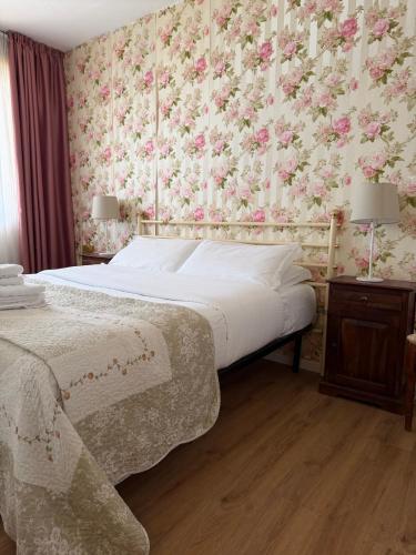 a bedroom with a bed with a floral wallpaper at White House in Cremia