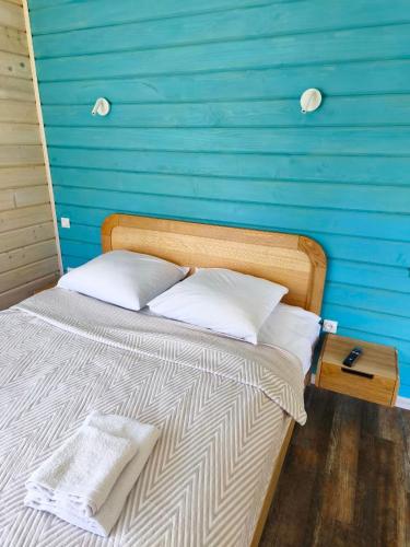 a bed in a room with a blue wall at Славський Двір in Slavske