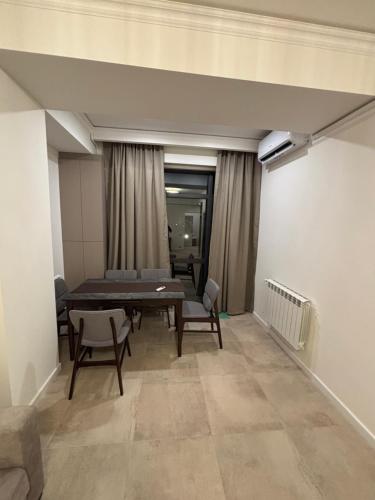 un soggiorno con tavolo e sedie in una stanza di Menechyan's Terrace a Yerevan