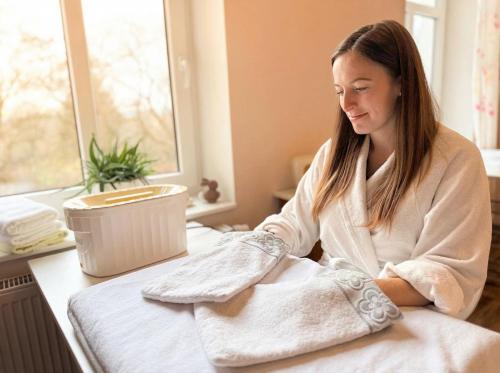 a woman sitting at a table with a towel at Boutique Hotel SwissHouse in Mariánské Lázně