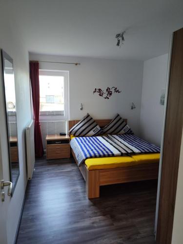 a small bedroom with a bed and a window at Nordsee Resort in Wangerland