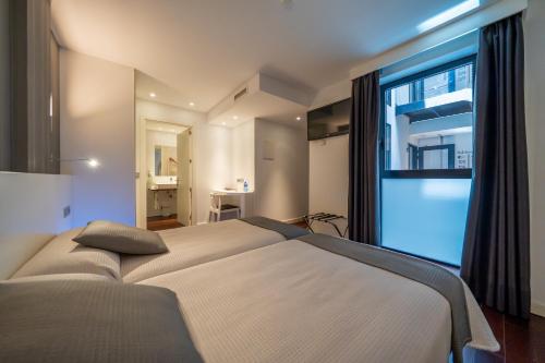 ein Schlafzimmer mit einem Bett und einem großen Fenster in der Unterkunft Hotel Apolonia Soria in Soria