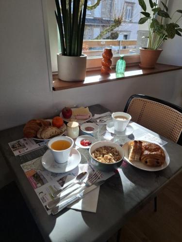 a table with breakfast foods and coffee on it at Le Grand Hôtel Ussel ''nouvelle Gérance 2023'' in Ussel