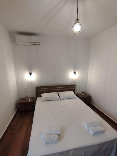a bedroom with a large white bed with two towels at Αίγλη Apartment in Ierissos