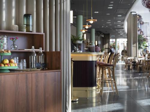 a restaurant with a bar with stools in a room at Radisson Blu Hotel Uppsala in Uppsala