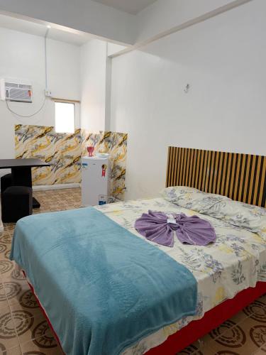 a bedroom with a bed with a blue blanket at Quarto no centro in Manaus