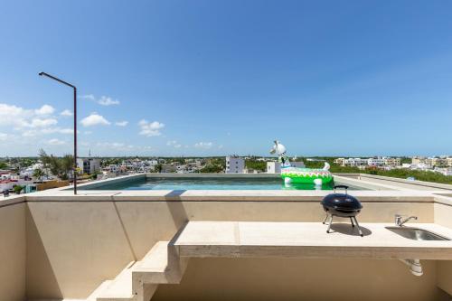 a kitchen counter with a sink and a swimming pool at Hola Donceles Suites in Cancún