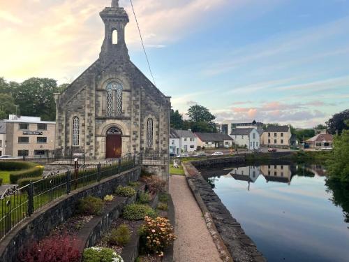 an old church with a reflection in the water at Riverside House in Donegal