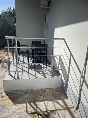 una ringhiera di metallo con due sedie e un tavolo di Vila Anja a Ksamil