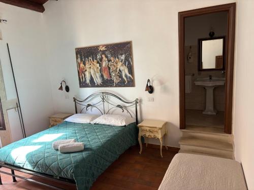 a bedroom with a bed with a painting on the wall at B&B Mirabella Rooms Ortigia in Syracuse