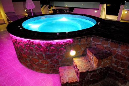 Un jacuzzi en una habitación con una pared de piedra. en Orfeas Apartments, en Kamari