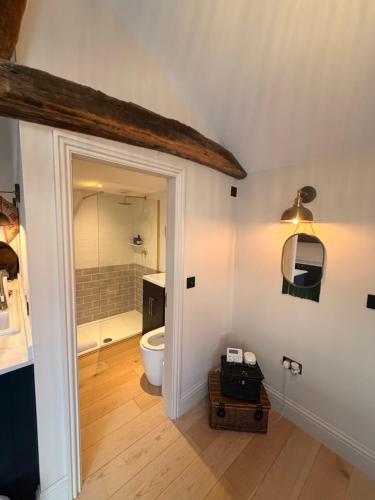 an attic bathroom with a toilet and a shower at The stables at the Grange in York