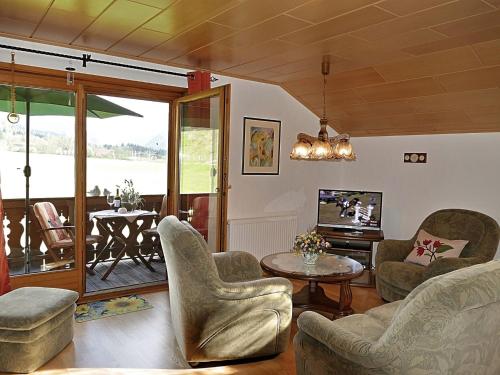 ein Wohnzimmer mit Stühlen, einem Tisch und einem TV in der Unterkunft Blissful Apartment in Altenau with Patio in Altenau