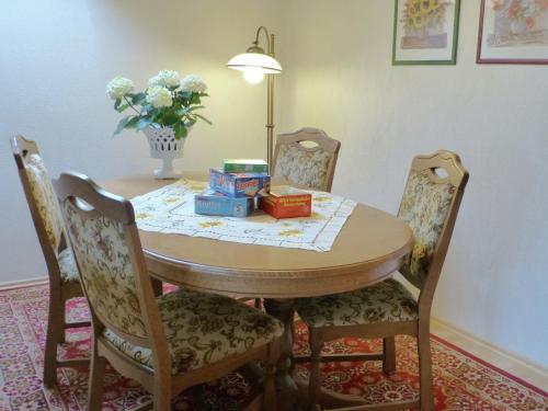 einen Esstisch mit Stühlen und eine Vase aus Blumen in der Unterkunft Blissful Apartment in Altenau with Patio in Altenau