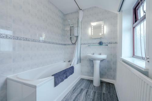 a bathroom with a sink and a tub and a toilet at Crossways Cottage, Dog-Friendly Cottage Near the Beach in Winterton-on-Sea