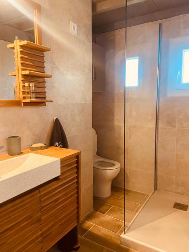 a bathroom with a toilet and a glass shower at Un cocon en Camargue in Saintes-Maries-de-la-Mer