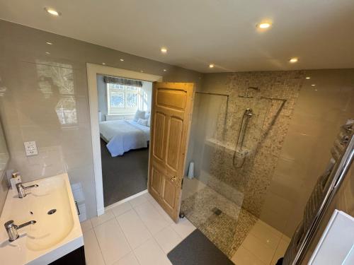 a bathroom with a sink and a shower and a bed at St Giles Lodge in Inverness