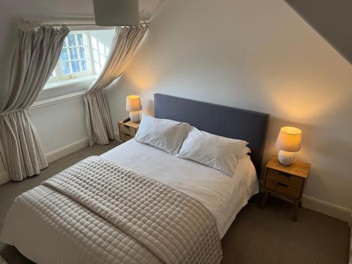 a bedroom with a bed with two lamps and a window at St Giles Lodge in Inverness