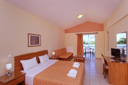 a bedroom with a bed and a desk and a television at Νηρηίδες Apartments Studios in Kyparissia