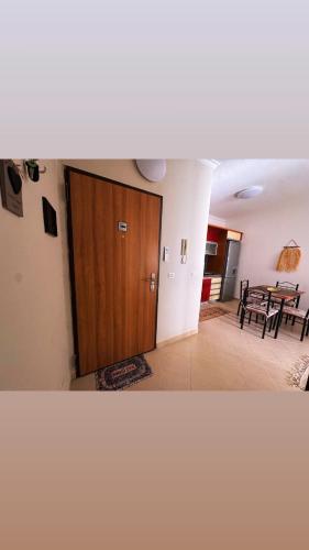ein Wohnzimmer mit einer Holztür und einem Tisch in der Unterkunft Teddy apartment in Durrës