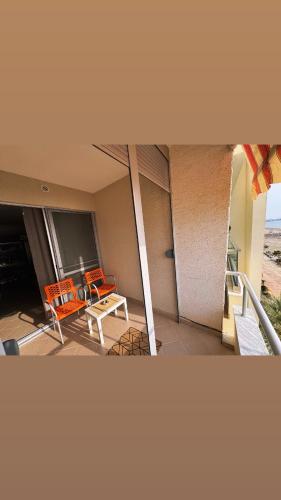ein Balkon mit zwei orangefarbenen Stühlen und einem Tisch in der Unterkunft Teddy apartment in Durrës
