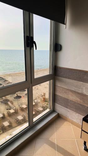 ein Zimmer mit Fenster und Blick auf den Strand in der Unterkunft Teddy apartment in Durrës