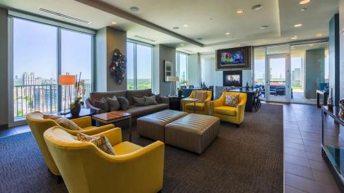 a living room with couches and chairs and a tv at Luxurious Midtown Apartment w Sky Lounge & Pool in Atlanta