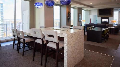 a kitchen with a island with chairs and a counter top at Luxurious Midtown Apartment w Sky Lounge & Pool in Atlanta