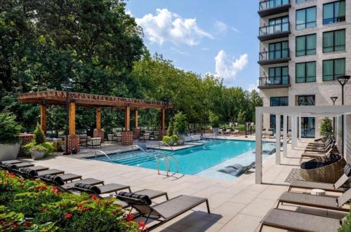 a pool at a hotel with chairs and a gazebo at Cozy Apartment in Atlanta in Atlanta